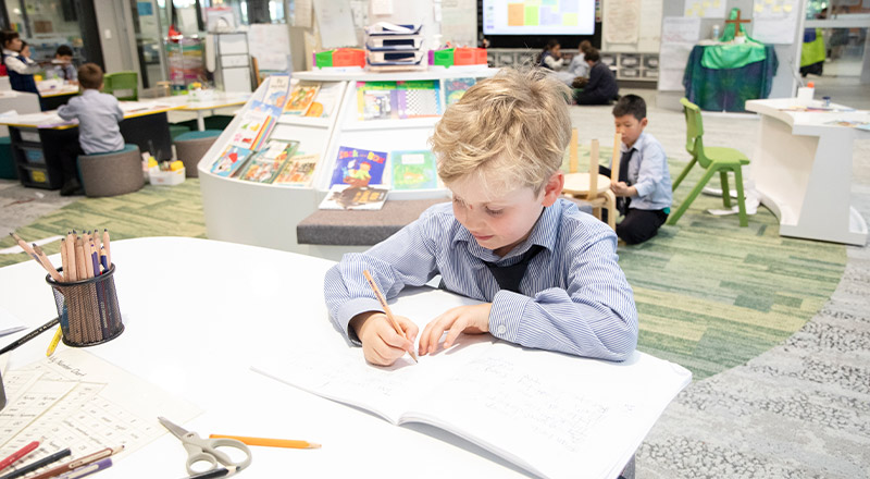 Student writing at his desk in the classroom at Our Lady of The Rosary Primary School Kellyville