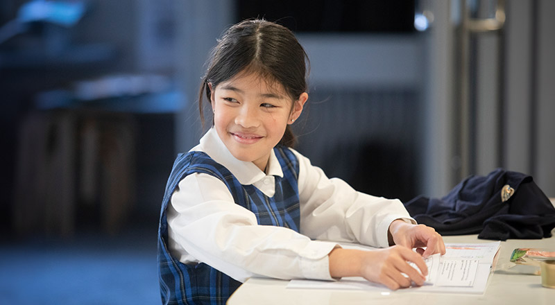 Students writing at her desk at Our Lady of The Rosary Primary School Kellyville