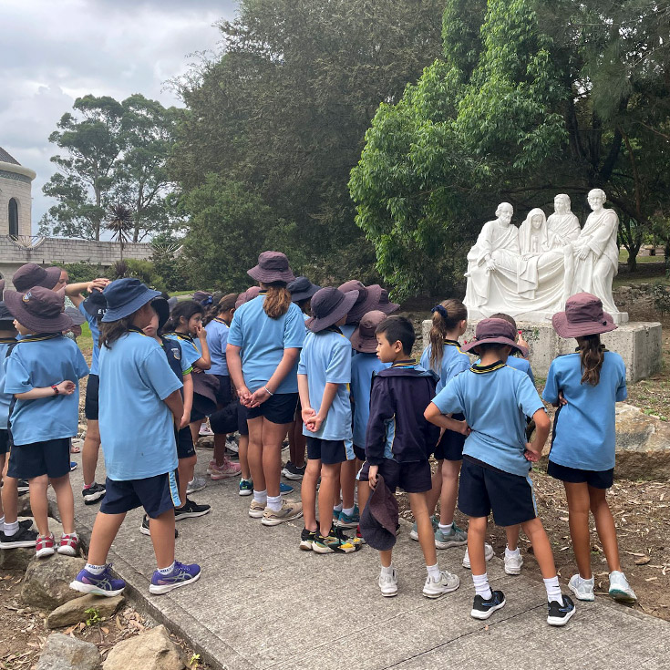 Students exploring a garden with religious statues during an excursion at Our Lady of The Rosary Primary School Kellyville