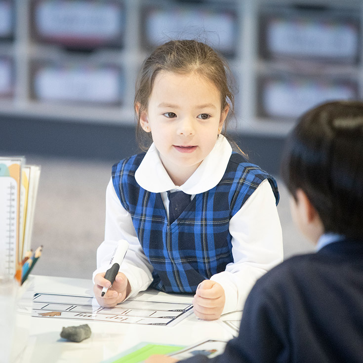 Student writing at her desk in the classroom at Our Lady of The Rosary Primary School Kellyville